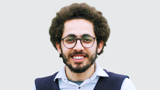 Portrait of Hisham Fadlallah smiling in a light blue collared shirt and blue vest