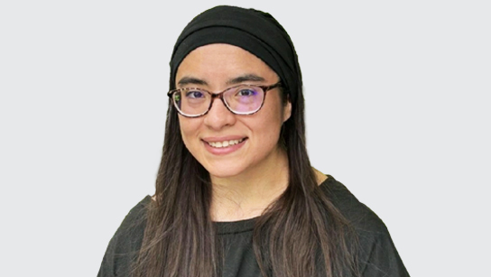Portrait of Sandra Flores-Castillo smiling in a dark gray shirt and black headband