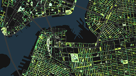 An abstract aerial view shows a dense city street grid rendered in glowing green and yellow lines. 