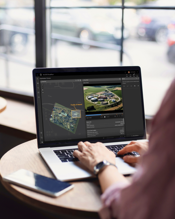 Analyst holding a tablet and typing while viewing video in ArcGIS Excalibur