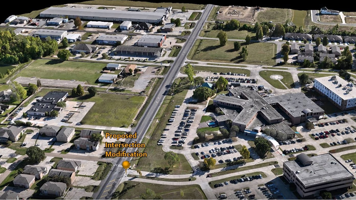 A bird’s eye view of commercial and residential buildings with a pin identifying an intersection to modernize
