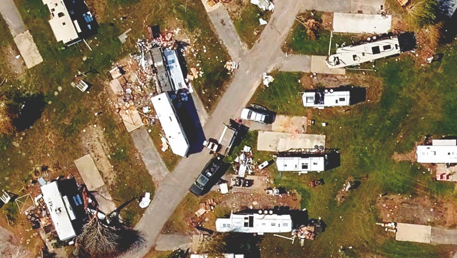 Vue de haut en bas d’un quartier de mobil-homes illustrant les dégâts matériels causés par un ouragan