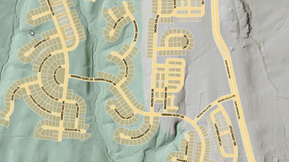 Uma visualização de cima para baixo de uma área residencial mostra casas identificadas em caixas vermelhas usando aprendizagem detalhada para extração de feições