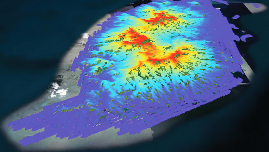 Remote sensing imagery of a large island region shows elevation with a dark blue (low) to red (high) color gradient