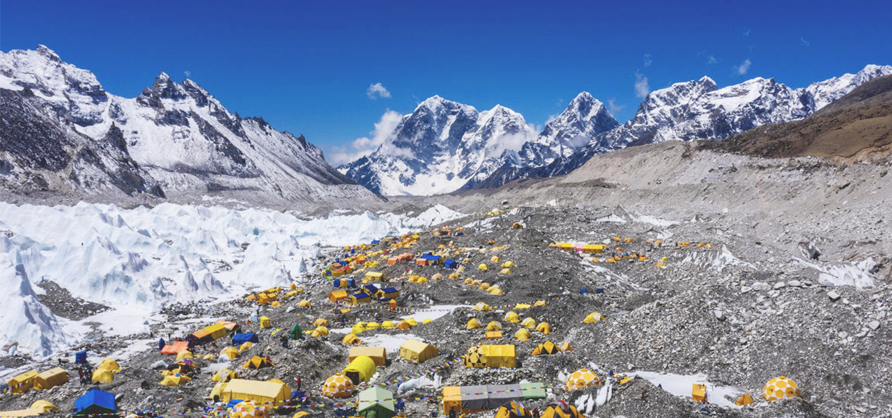 Drone imagery shows the Mt. Everest base camp full of yellow and blue tents, surrounded by snowy mountains