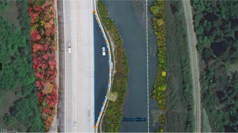 An aerial drone view of a highway near fall foliage and green trees