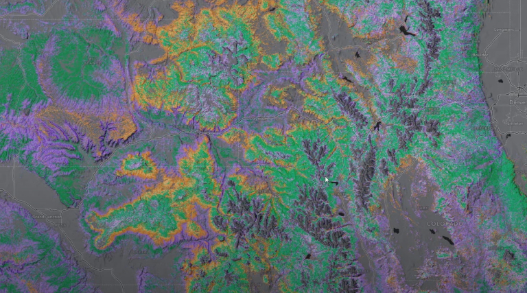 A satellite image of a forested landscape shows remotely sensed land cover data in a purple, orange, and green gradient