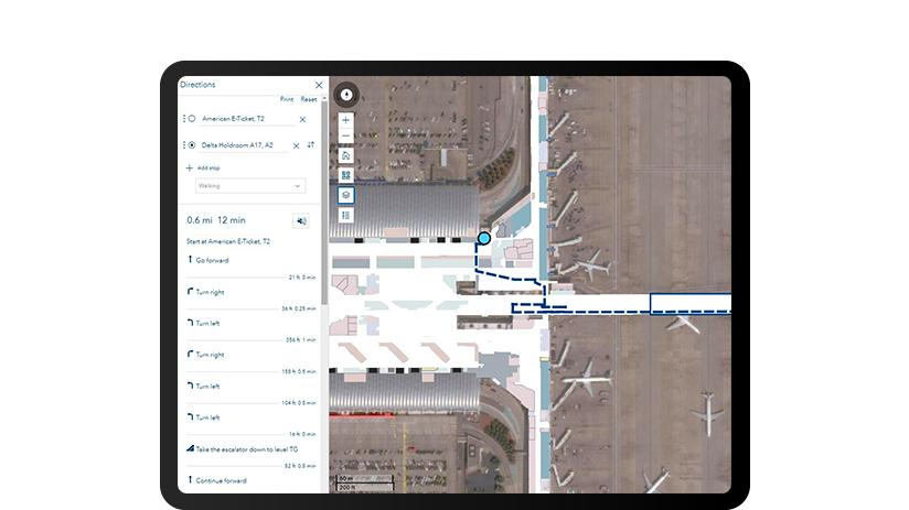 A tablet screen showing an overhead shot of an airport terminal with turn-by-turn directions on the left