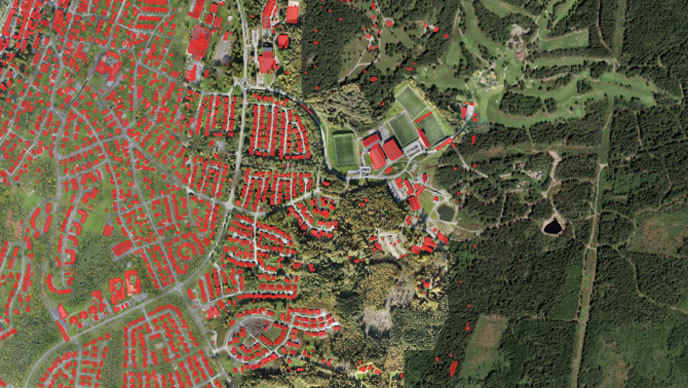An aerial image of a town with extracted buildings in red and green land