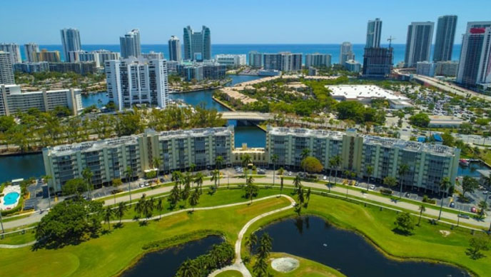 Aerial image of a Florida skyline with green land, blue water, and large buildings