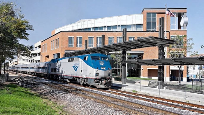 An image of a blue and white train leaving a train station