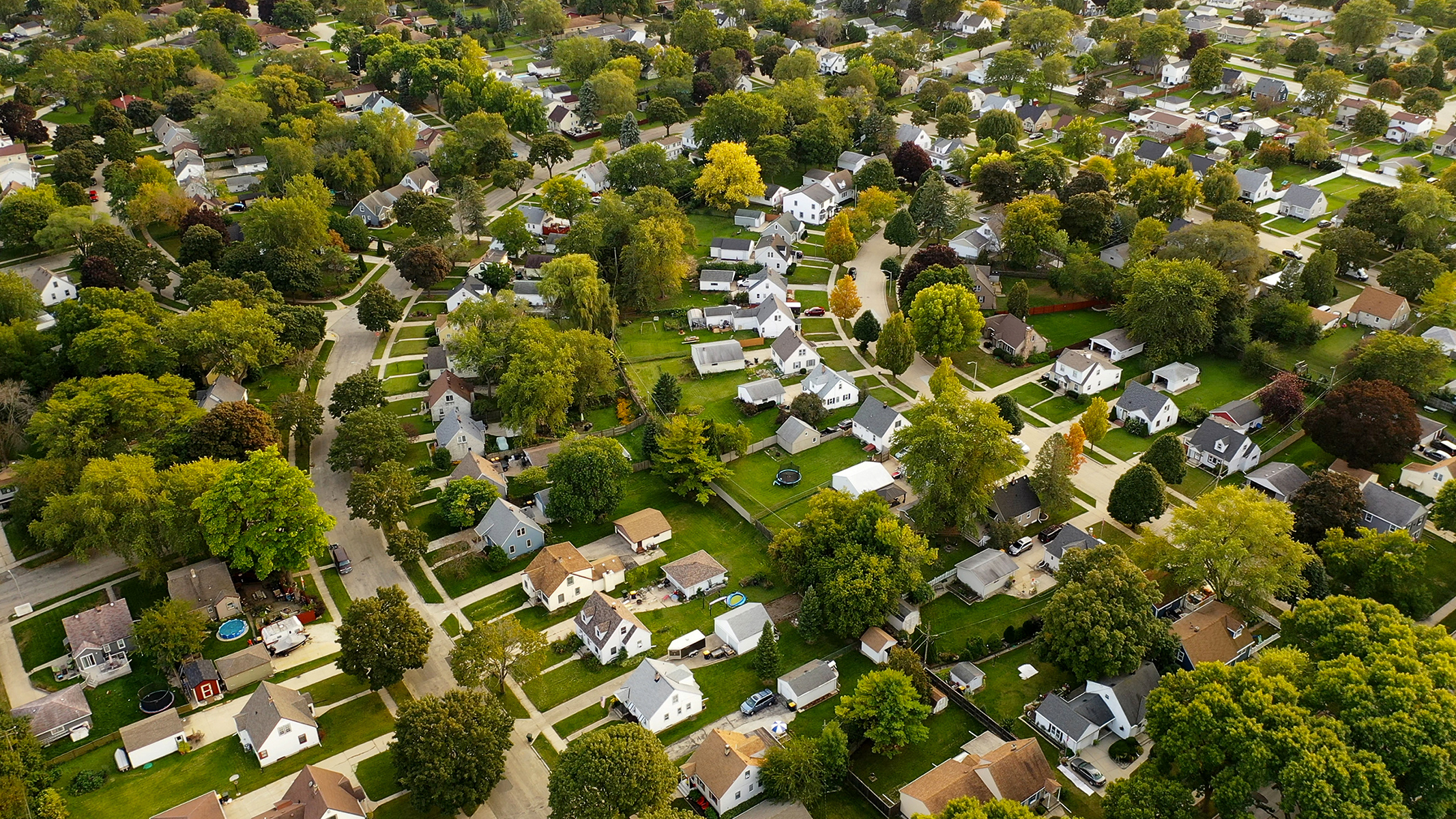 Aerial view of suburban neighborhood with curved streets and many trees