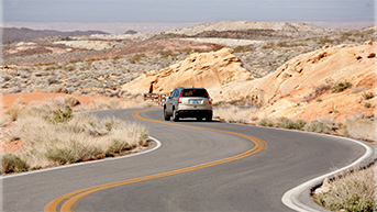 A Honda CR-V driving on a winding desert road