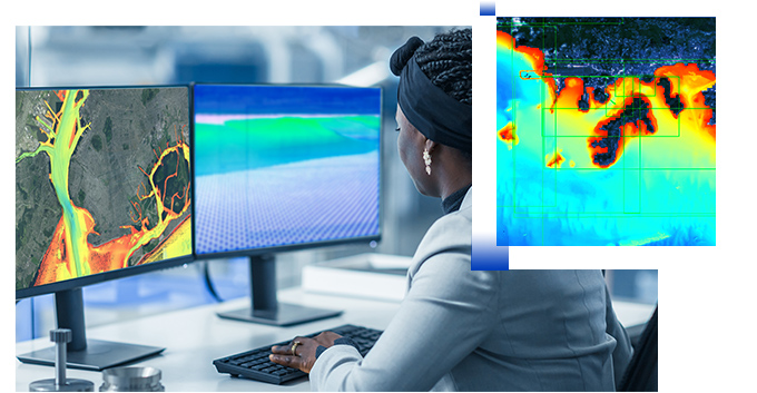 Young woman looking at 2 computer monitors with hydrographic data and digital image of bathymetric information system