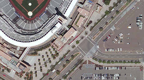 The view from a satellite of a baseball stadium and a nearby parking lot