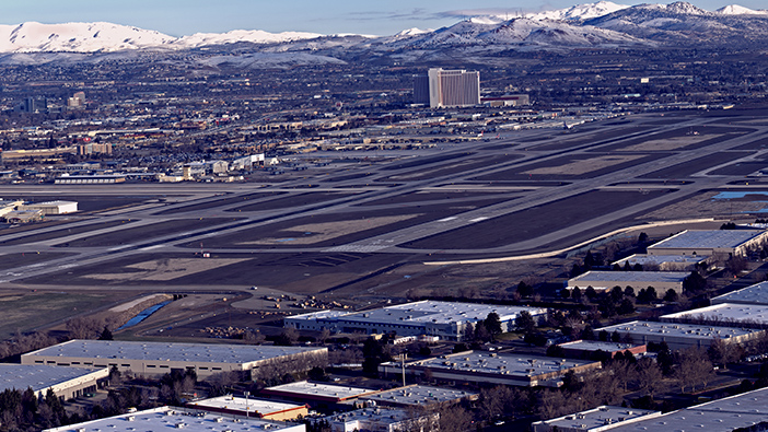 Bild des Renoe-Tahoe International Airport mit schneebedeckten Bergen im Hintergrund und mehreren Gebäuden