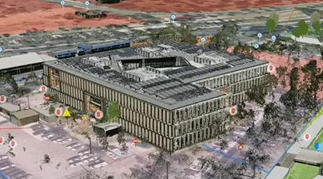 Luftansicht eines 3D-Gebäudemodells, das einen großen Krankenhauskomplex inmitten von Parkplätzen und Bäumen abbildet