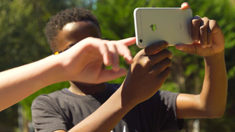 Kinder in Johns Creek, GA, nutzen ArcGIS Hub auf einem Smartphone