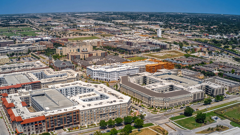 A sprawling city stretching into the distance under a clear blue sky