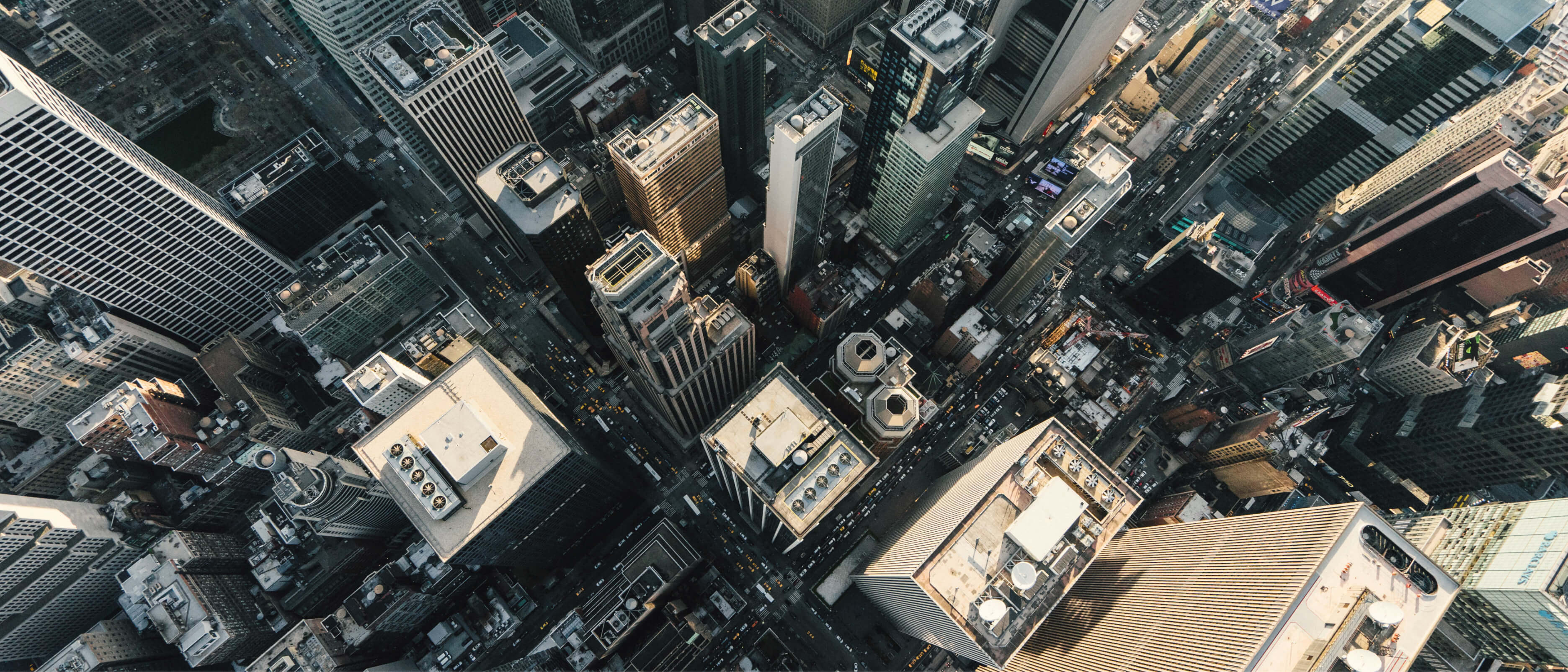 Aerial view of a downtown area with high rise buildings overlaid with a play button that opens a video modal