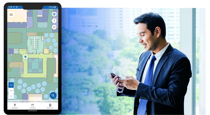 Un hombre con traje azul marino mirando un teléfono móvil junto a una imagen insertada de un teléfono móvil con un mapa interior de unas instalaciones 