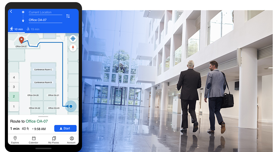 Duas pessoas de terno caminhando em um saguão bem iluminado, sobreposto com a ilustração de um telefone celular exibindo a navegação interna em um prédio de escritórios 