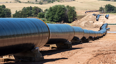  A long, above ground pipeline running across dry, brown land