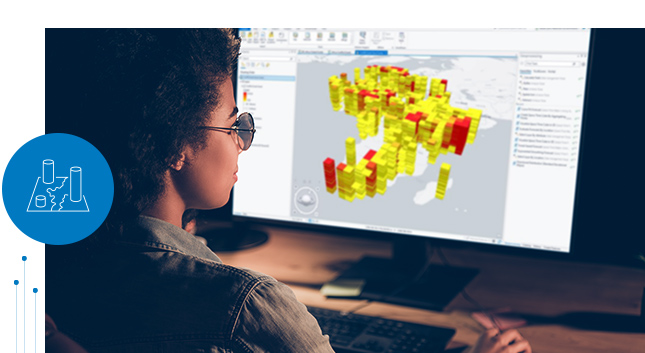 Woman at a desk looking at multiple data sources and types visualized in 2D and 3D on a map on a computer