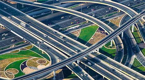 An aerial view of a highway with multiple overpasses and some green areas