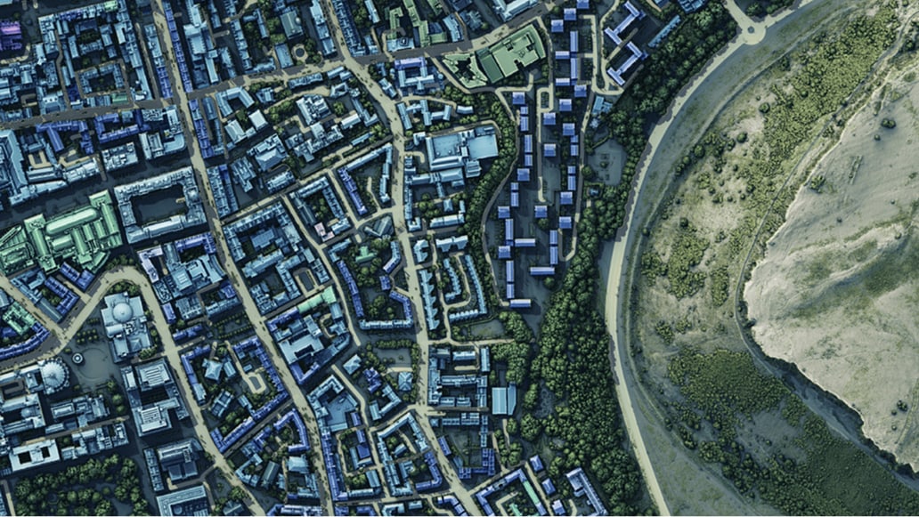 An aerial view of dense urban blocks next to a river bend