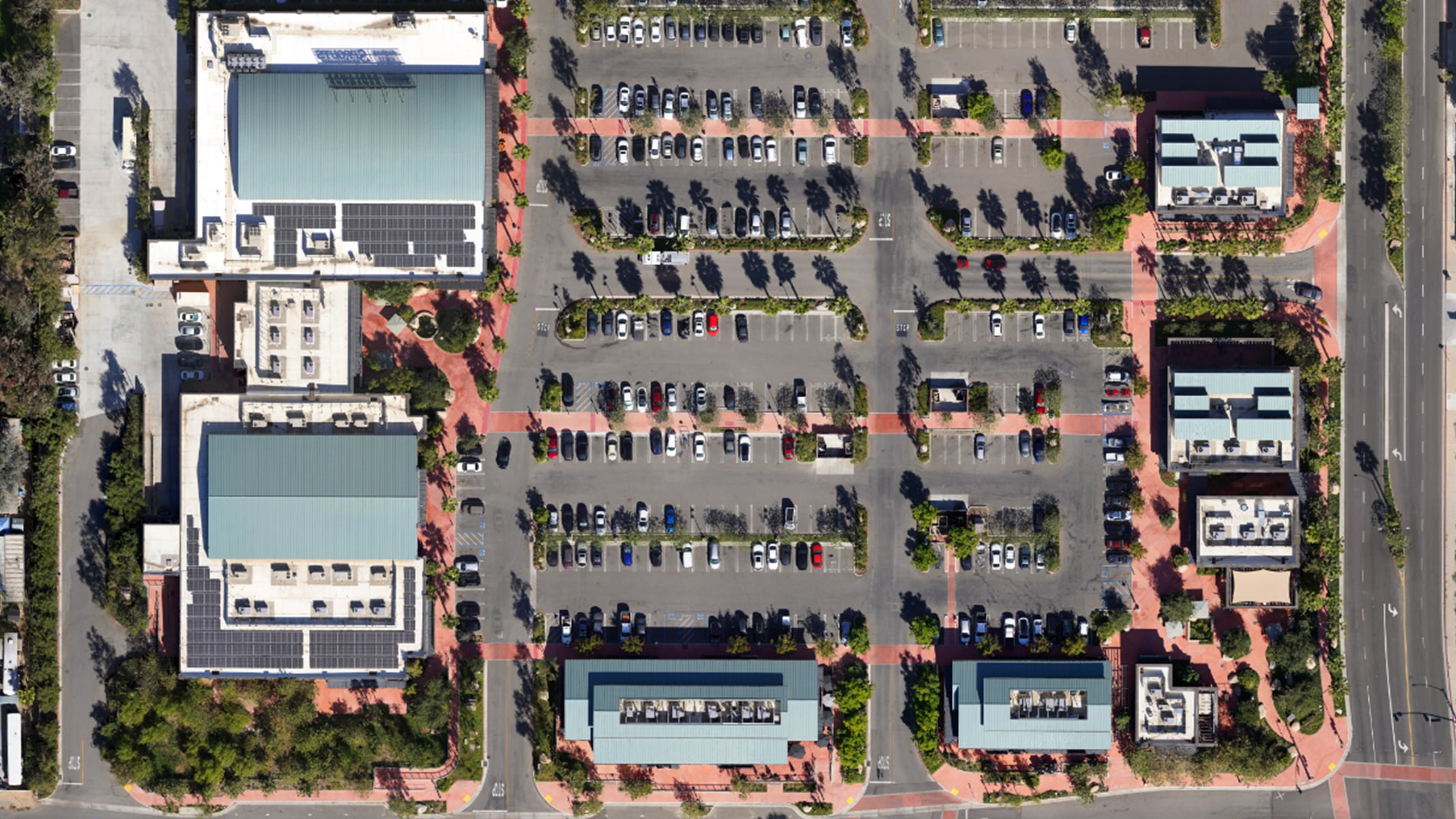 An aerial view of a commercial development surrounding a parking lot 