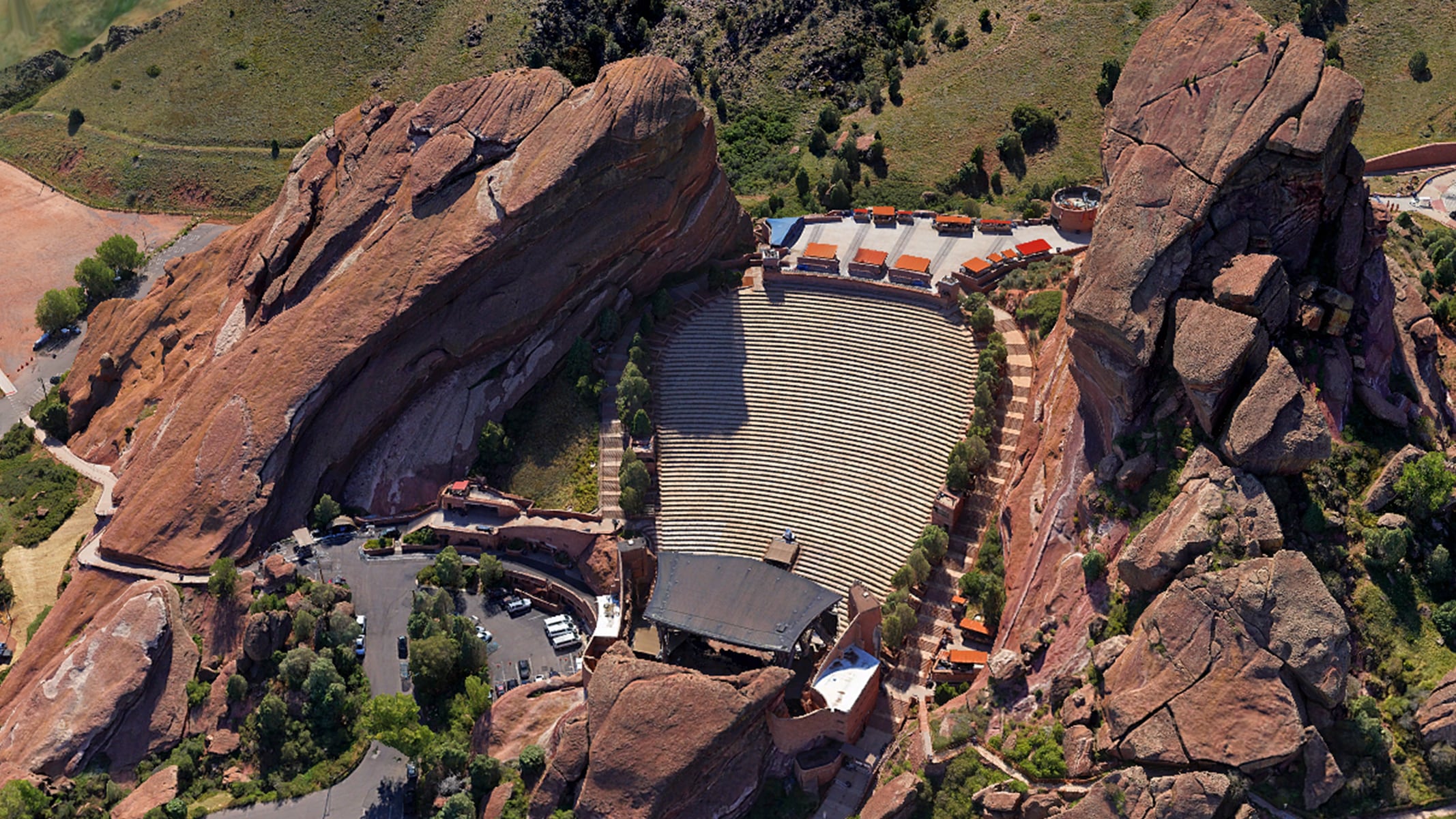 An aerial view of buildings with terracotta roofs bisected by a street