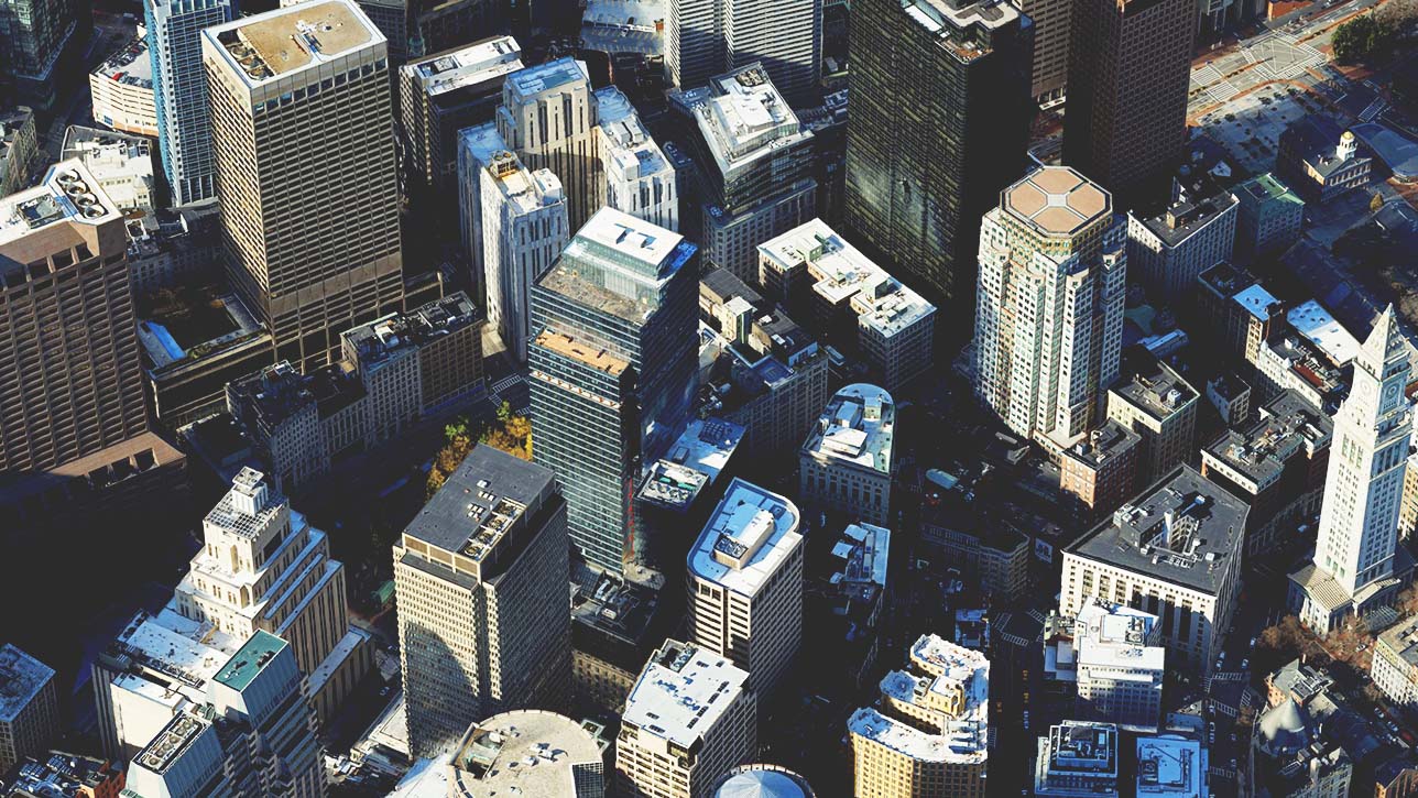 Ein Bild einer Stadt mit einer Gruppe niedriger und hoher Gebäude, das ein 3D-Mesh mit Textur darstellt 