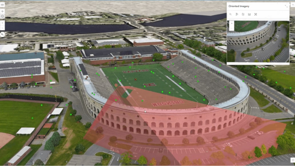 A digital model of a stadium partially overlaid with a transparent red triangle 