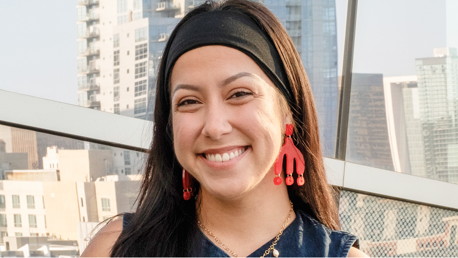 Karina Amalbert smiling with a city skyline in the background