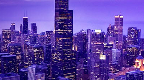 Urban city at night with tall buildings and skyscrapers lit up