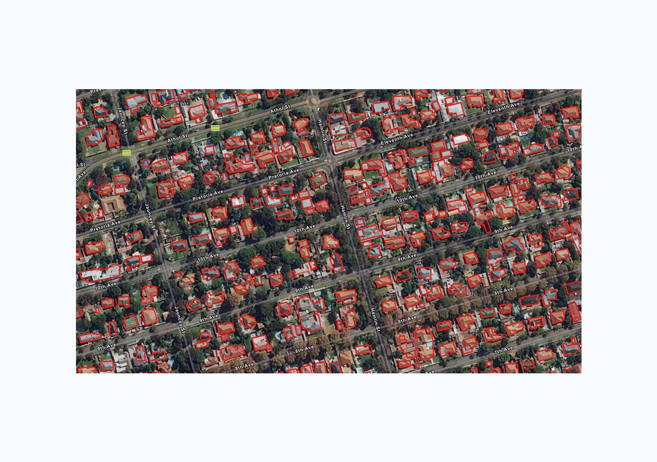 Imagen aérea de casas residenciales con cuadrados rojos superpuestos que representan la aplicación de modelos preentrenados 