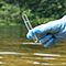 A hand with a blue glove holding a test tube with water sample from a river 