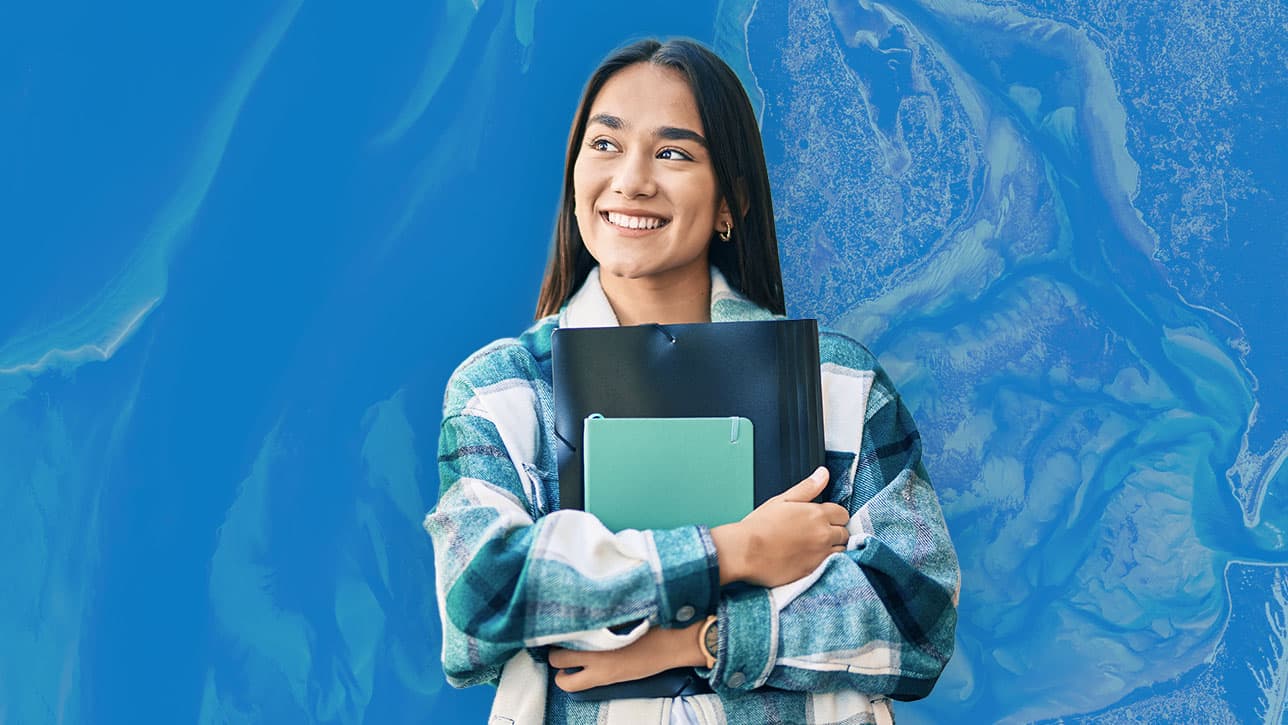 A student holding folders and notebook