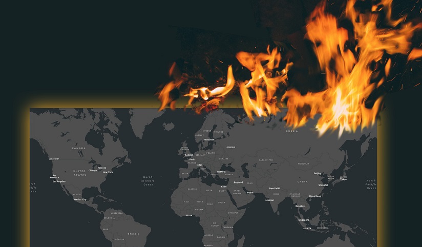 A grey world map surrounded by black and partially engulfed in flames