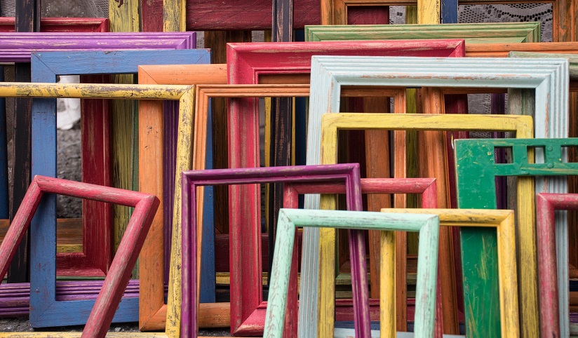 A stacked collection of wooden multi-colored picture frames
