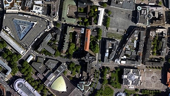 Un'immagine aerea di una città che mostra alberi, edifici e strade che rappresenta un ortomosaico DSM