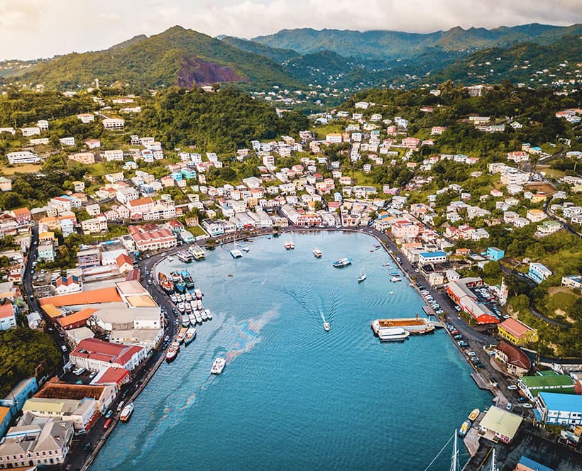 An island nation with rich green mountains and a busy dock