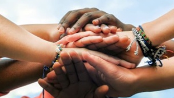 A group of hands stacked on top of one another 