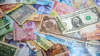 Different monetary bills from around the world including a green $1 bill from the United states