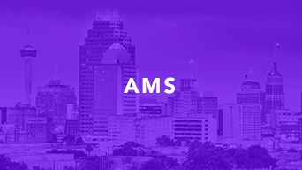 A downtown area with tall buildings overlaid in purple graphic that reads AMS