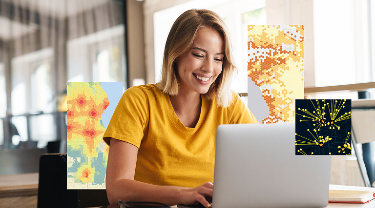 A woman in a yellow shirt smiles as she looks a a laptop screen she is using to build location-powered applications