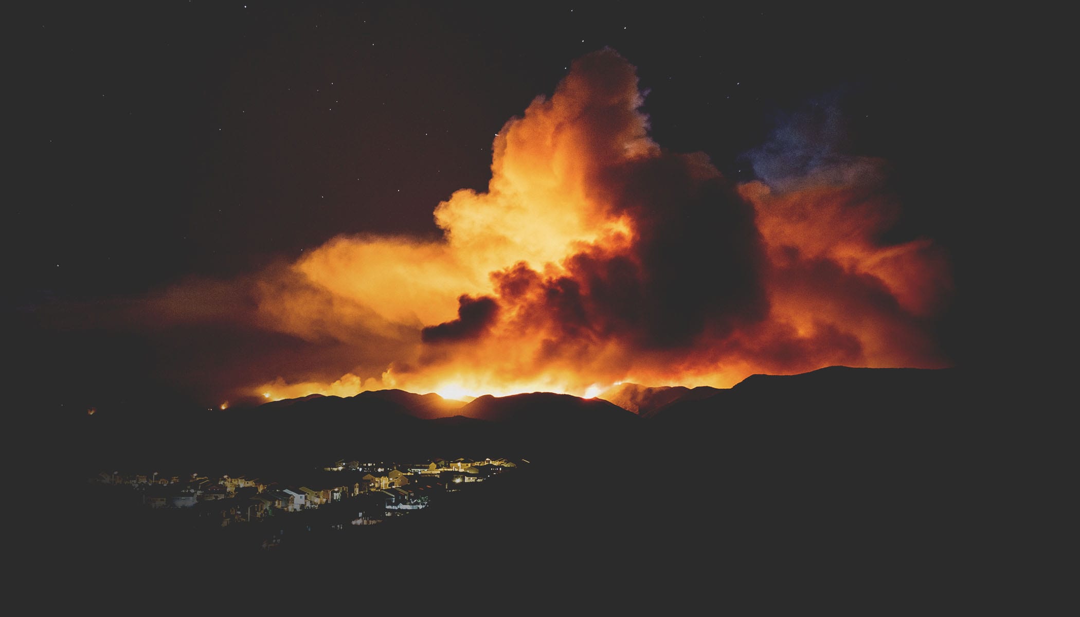 Cloud of smoke illuminated by fire below it