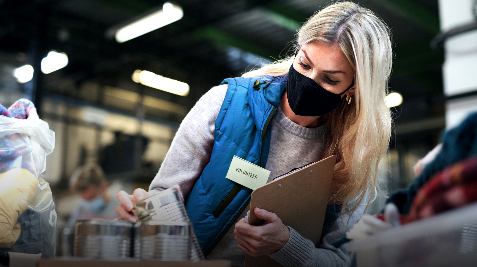 A volunteer at a food bank taking inventory of donations