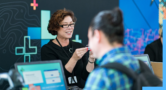 Esri User Conference の参加者の手伝いをする女性